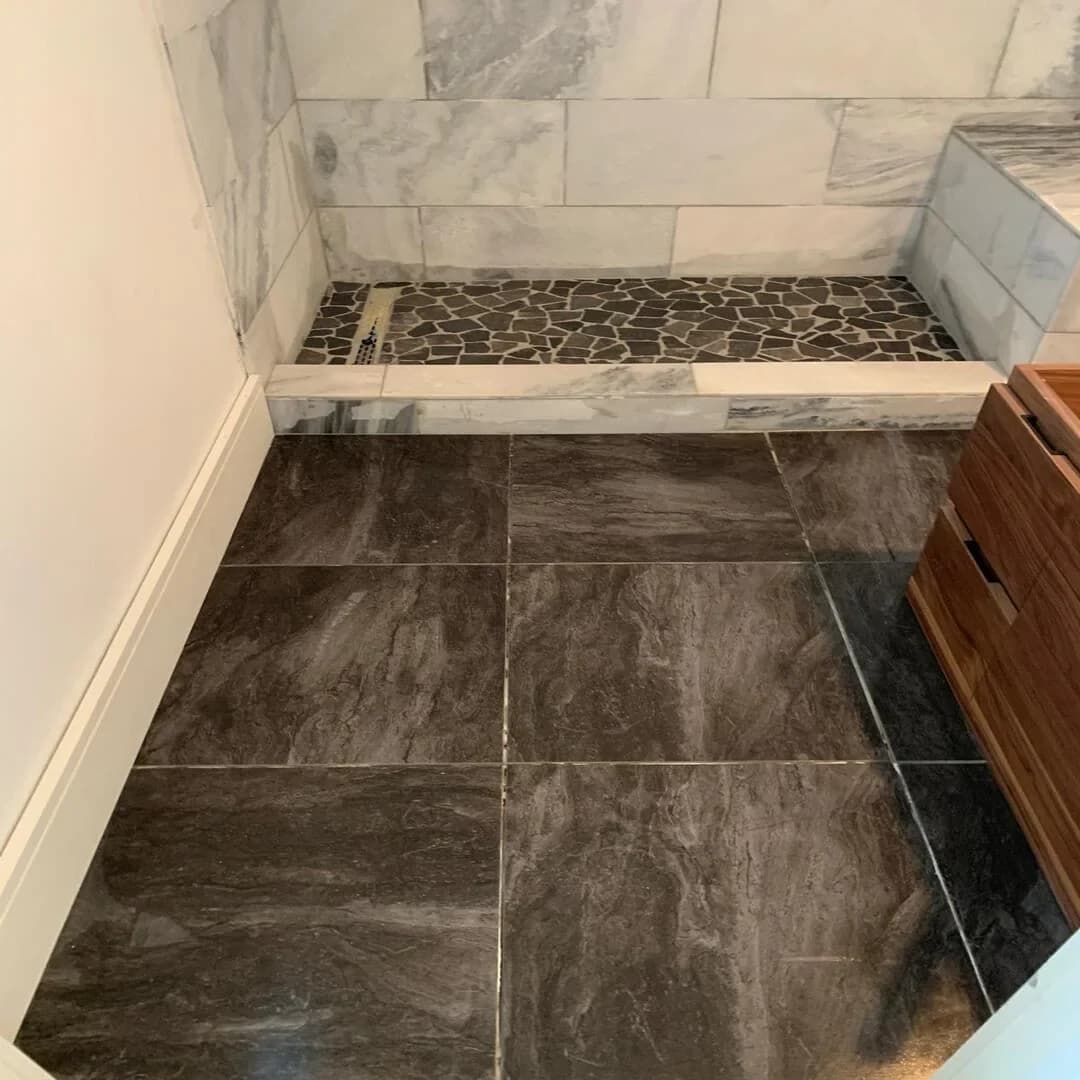 Marble shower and dark porcelain tile floor by JC General Painting in South Florida