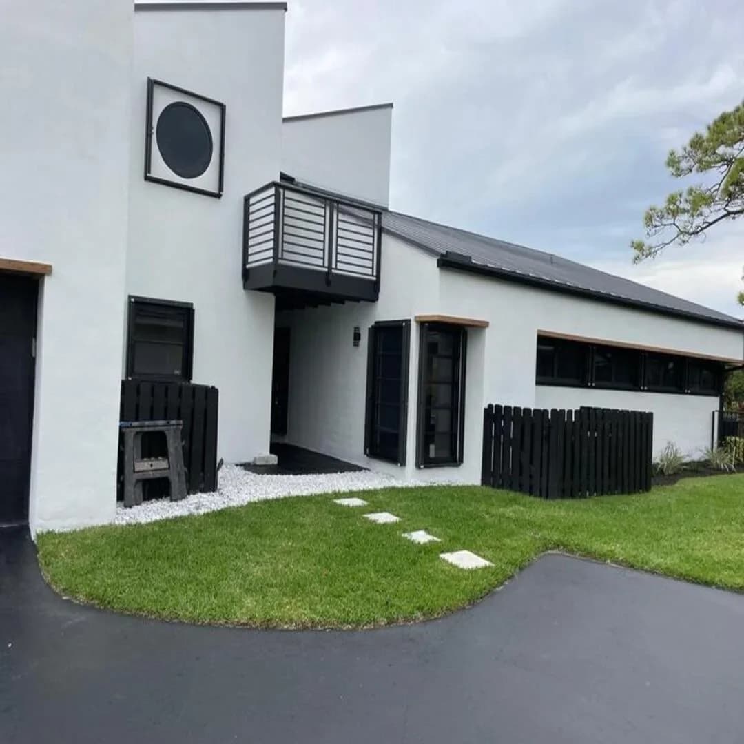 Contemporary white-and-black home exterior by JC General Painting in South Florida